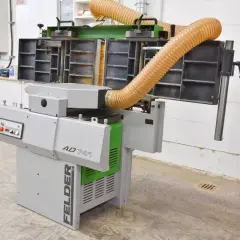 Machine à bois FELDER AD 741, avec ses tuyaux d'aspiration orange, prête à transformer le bois.