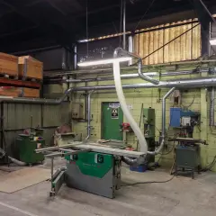 Atelier de menuiserie avec scie, dégauchisseuse, et une aspiration atelier bois occasion pour un environnement de travail propre.