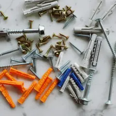 Diverses chevilles et vis, prêtes à mettre une cheville dans un mur placo.