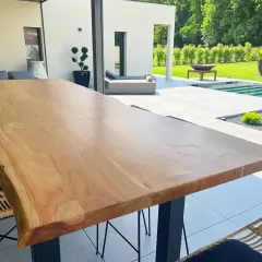 Une belle table en bois brut, parfaite pour profiter de l'extérieur. Peut-on mettre une table en bois dehors ? Oui, si elle est bien entretenue !