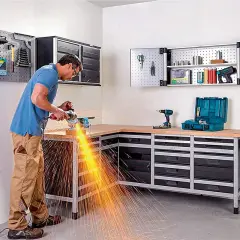 Un homme utilise une meuleuse d'angle dans son atelier bien rangé, créant un spectacle d'étincelles vives.