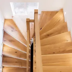 Escalier en bois clair, idéal pour un entretien facile à l'huile de lin. Lumières intégrées pour un éclairage doux.
