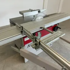 Scie circulaire Hammer K3 avec table coulissante, guide parallèle et lame de scie visible. Idéale pour les travaux de menuiserie précis.