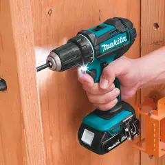 Comment reconnaître Makita Pro : une perceuse sans fil turquoise et noire de Makita est utilisée pour visser dans du bois.