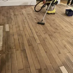 Nettoyage d'un parquet ancien avant vitrification. La question "vitrification parquet tous les combien" se pose souvent pour préserver sa beauté.