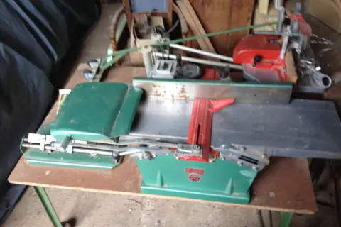 Toupie Kity verte et rouge, machine à bois ancienne, prête à façonner le bois.