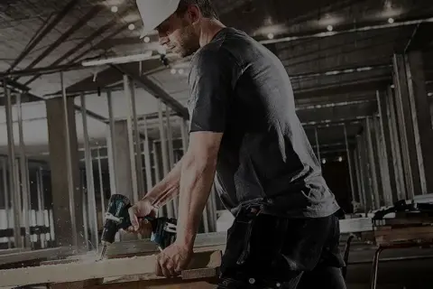 Un ouvrier utilise une perceuse Makita sur un chantier. Il est important d'enregistrer votre garantie Makita non enregistrée pour une protection optimale.
