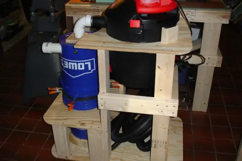 Aspirateur copeaux Leman ASP152 sur un support en bois avec un seau bleu Lowe's.