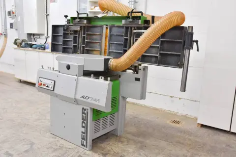 Machine à bois FELDER AD 741, avec ses tuyaux d'aspiration orange, prête à transformer le bois.