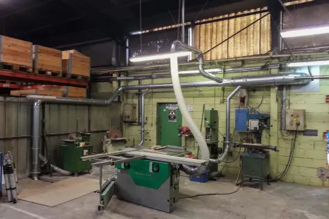 Atelier de menuiserie avec scie, dégauchisseuse, et une aspiration atelier bois occasion pour un environnement de travail propre.