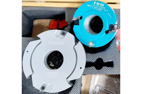 Deux fraises de toupie occasion, une grise "ISOCELE" et une bleue "ISO", prêtes pour des travaux de menuiserie.
