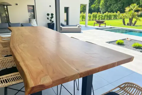 Une belle table en bois brut, parfaite pour profiter de l'extérieur. Peut-on mettre une table en bois dehors ? Oui, si elle est bien entretenue !
