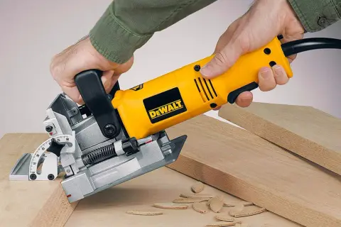 Main jaune DeWalt, une lamelleuse, utilisée pour assembler des planches de bois.