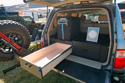 Aménagement de coffre de véhicule tout-terrain avec un tiroir coulissant en bois, idéal pour fabriquer un tiroir coulissant en bois pratique pour le camping.