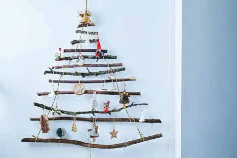 Arbre de Noël mural en branches, une charmante deco de noel en bois fait maison, orné de petites figurines et d'étoiles.