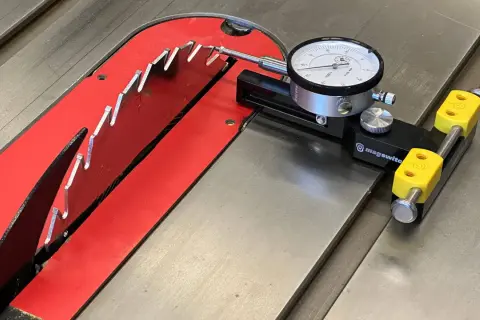 Réglage précis de la lame de scie circulaire sur table avec un comparateur pour fabriquer un guide.