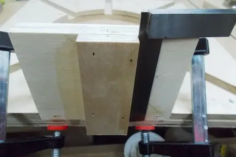 Assemblage d'un plan lunette de tournage en bois, maintenu par des serre-joints.