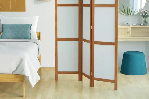 Un paravent en bois et tissu blanc, parfait pour fabriquer un coin intime dans une chambre.