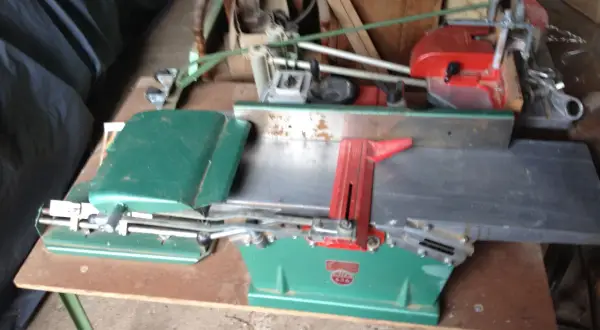 Toupie Kity verte et rouge, machine à bois ancienne, prête à façonner le bois.