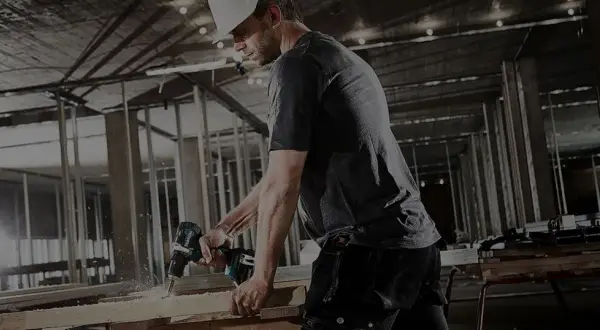 Un ouvrier utilise une perceuse Makita sur un chantier. Il est important d'enregistrer votre garantie Makita non enregistrée pour une protection optimale.