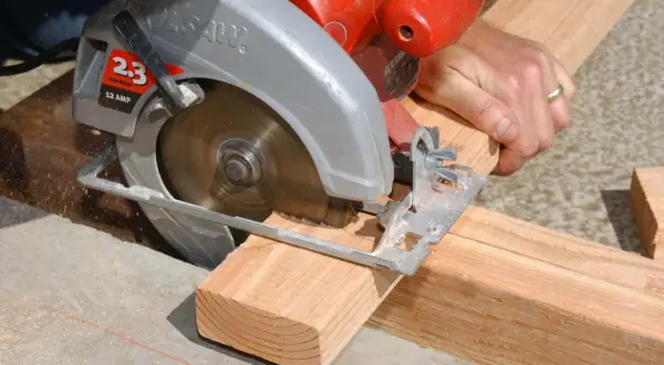 Maintenant, je me demande qui a inventé la scie circulaire. Un artisan utilise une scie circulaire pour couper du bois.