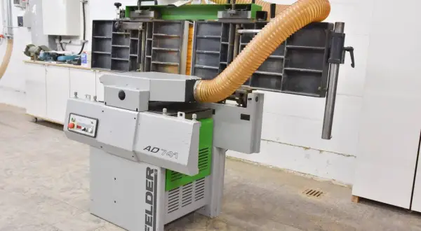 Machine à bois FELDER AD 741, avec ses tuyaux d'aspiration orange, prête à transformer le bois.