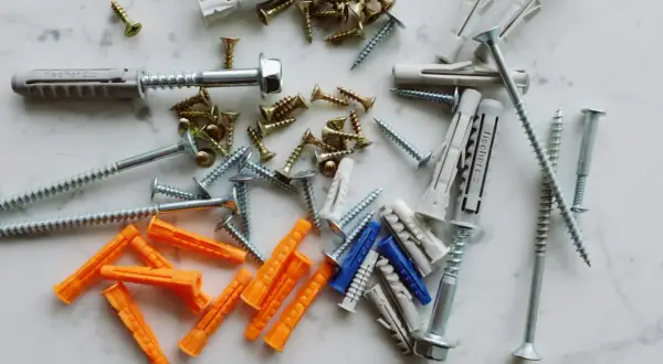 Diverses chevilles et vis, prêtes à mettre une cheville dans un mur placo.