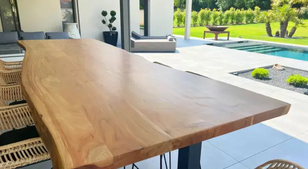 Une belle table en bois brut, parfaite pour profiter de l'extérieur. Peut-on mettre une table en bois dehors ? Oui, si elle est bien entretenue !