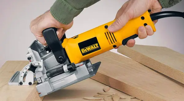 Main jaune DeWalt, une lamelleuse, utilisée pour assembler des planches de bois.
