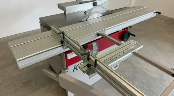 Scie circulaire Hammer K3 avec table coulissante, guide parallèle et lame de scie visible. Idéale pour les travaux de menuiserie précis.