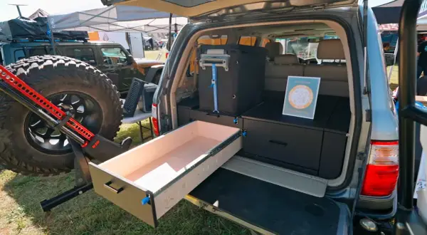 Aménagement de coffre de véhicule tout-terrain avec un tiroir coulissant en bois, idéal pour fabriquer un tiroir coulissant en bois pratique pour le camping.