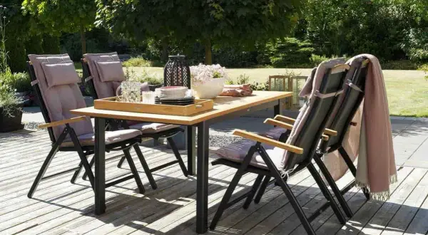 Ensemble de jardin avec table en bois pour table extérieur et chaises confortables, prêt pour un repas ensoleillé.