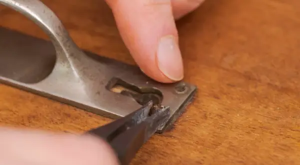 Maintenant, vous savez comment enlever une vis foirée. Une pince à épiler retire un morceau de vis endommagé d'une poignée de porte.