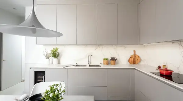 Cuisine moderne avec des meubles hauts gris épurés. La hauteur des meubles hauts cuisine est optimisée pour un rangement maximal.