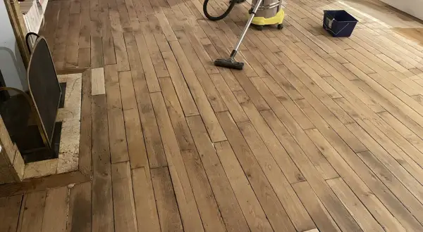 Nettoyage d'un parquet ancien avant vitrification. La question "vitrification parquet tous les combien" se pose souvent pour préserver sa beauté.