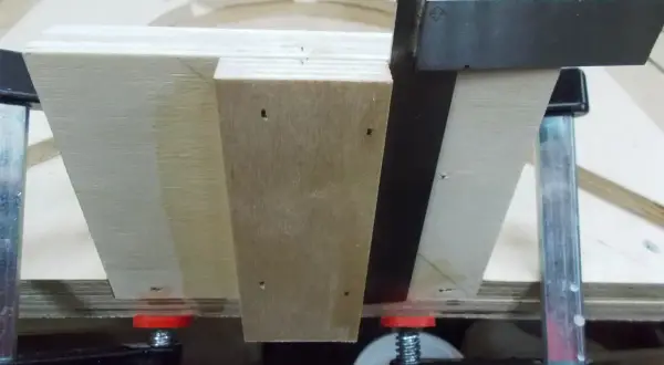 Assemblage d'un plan lunette de tournage en bois, maintenu par des serre-joints.