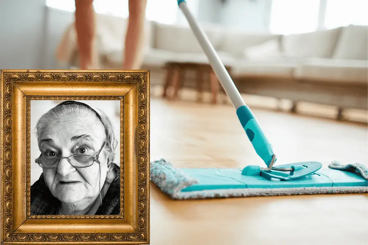 Portrait d'une grand-mère souriante à côté d'une serpillère sur un parquet. Une astuce de grand-mère pour nettoyer un parquet.