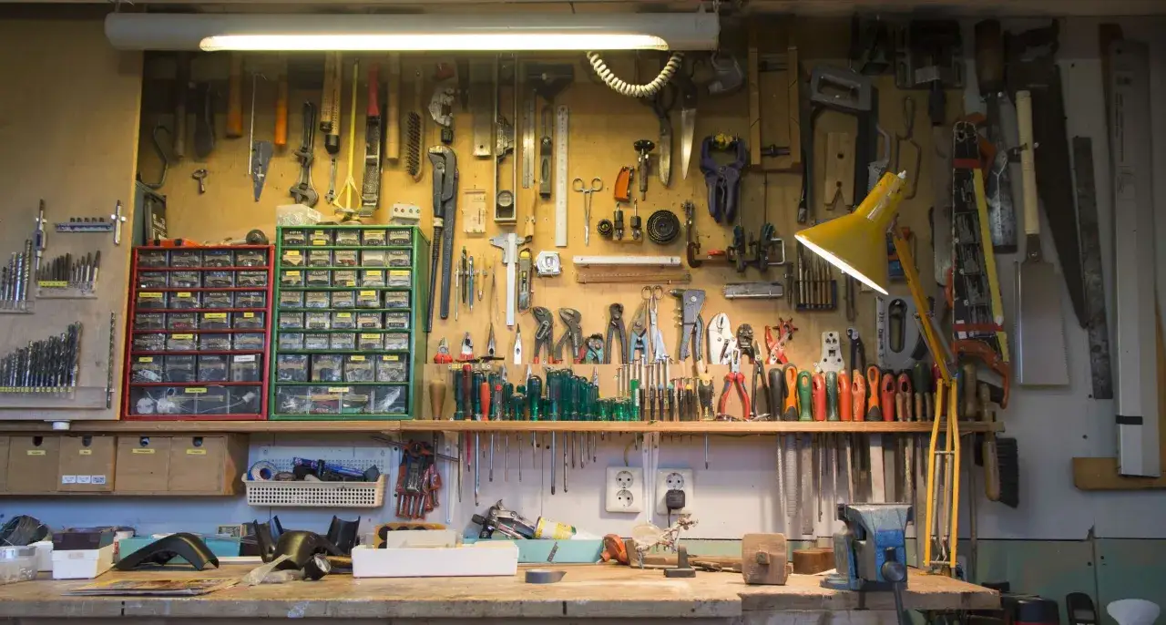 Un atelier bien organis&eacute; avec un rangement fait maison : outils suspendus, tiroirs de visserie et &eacute;tabli fonctionnel.