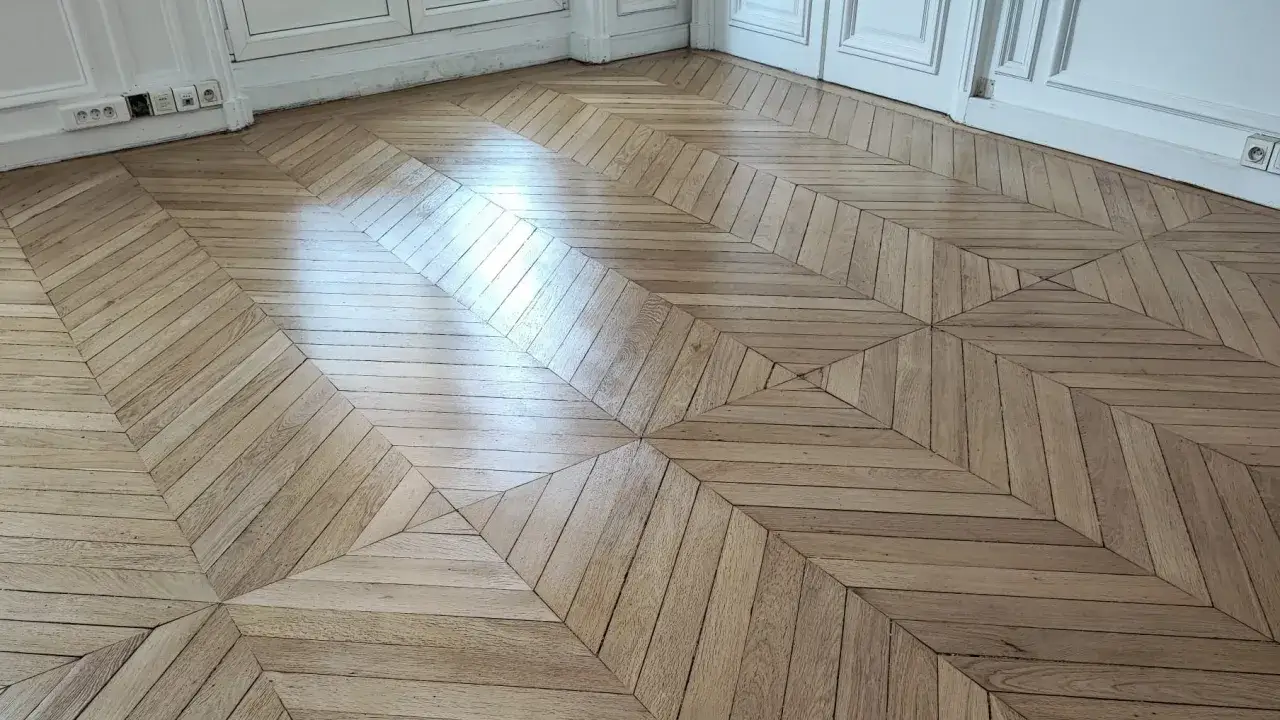 Parquet en bois clair avec un motif g&eacute;om&eacute;trique. La vitrification du parquet tous les combien est une question de fr&eacute;quence d'usage et d'entretien.