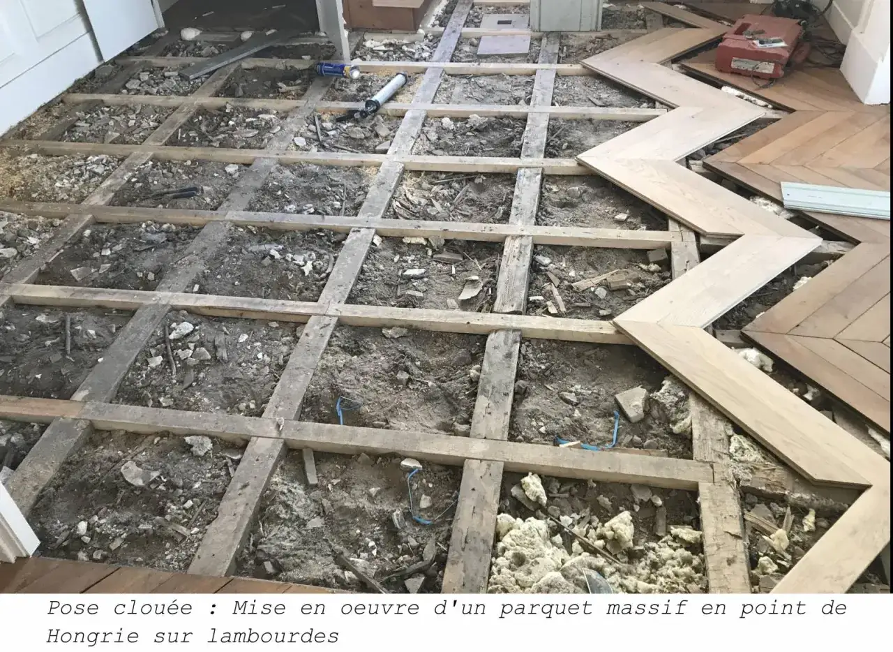 Pose clouée : Mise en œuvre d'un parquet massif en point de Hongrie sur lambourdes. Début de la pose, les lattes de bois sont prêtes à être fixées.