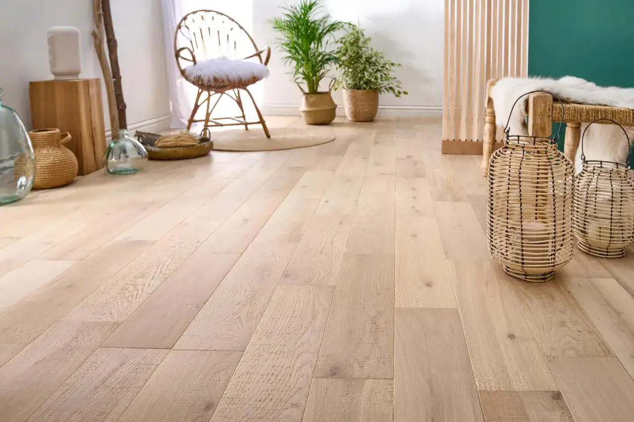 Un parquet brut clair, avec des vases en osier et une chaise en rotin, invite à se demander : peut on laisser un parquet brut ?