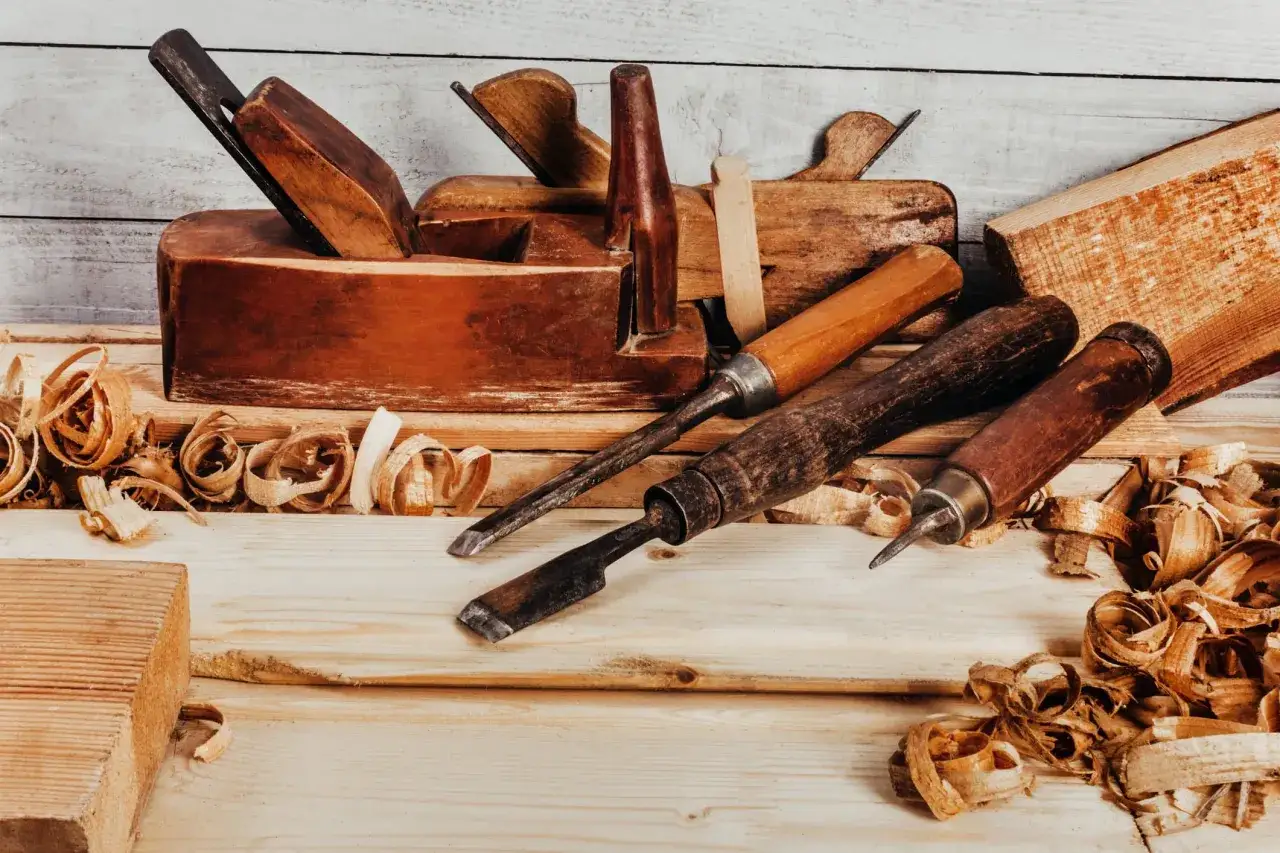 Ensemble d'un vieil outil ébéniste, des ciseaux et des copeaux de bois sur une surface en bois.