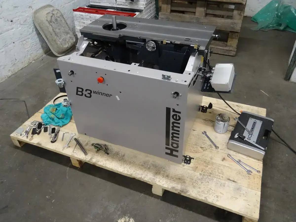 Le marteau B3 Winner, une machine à bois, est prêt pour l'assemblage sur une palette avec des outils.