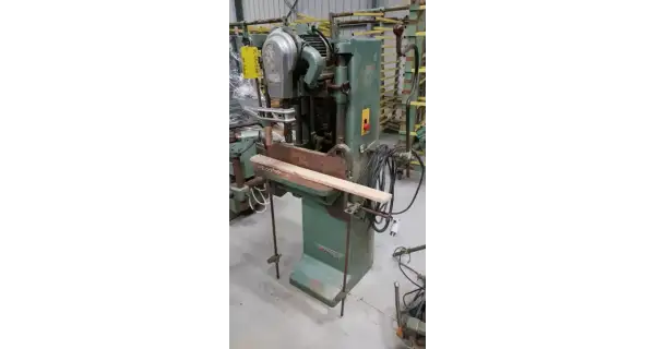 Machine à bois verte, une mortaiseuse à chaîne, avec une pièce de bois en position.