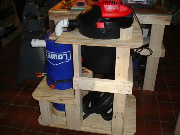 Aspirateur copeaux Leman ASP152 sur un support en bois avec un seau bleu Lowe's.