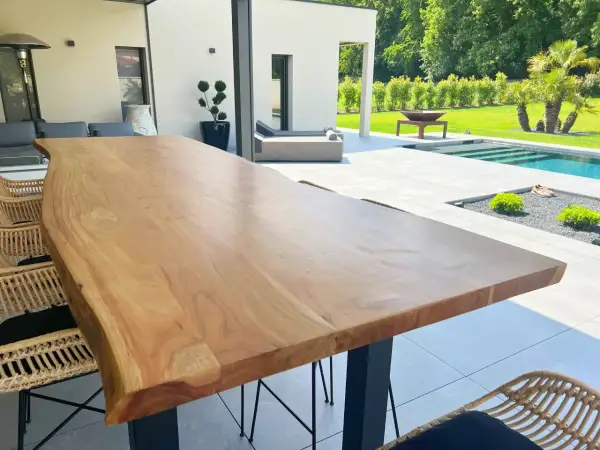 Une belle table en bois brut, parfaite pour profiter de l'extérieur. Peut-on mettre une table en bois dehors ? Oui, si elle est bien entretenue !