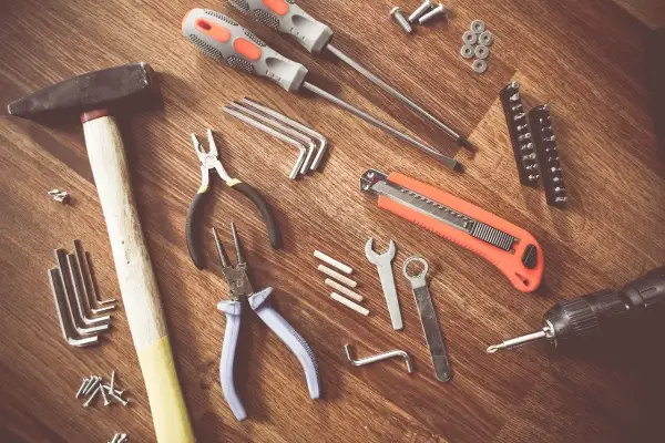 Un marteau, des tournevis, des pinces, une lame rétractable, des clés Allen et une perceuse : tous ces nom d'outils de bricolage sont prêts pour un projet.