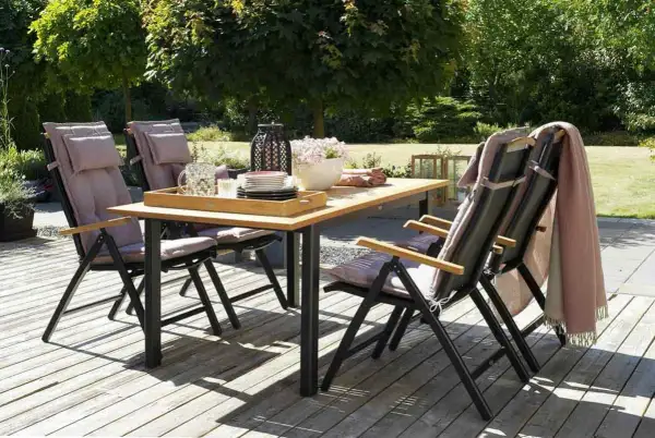 Ensemble de jardin avec table en bois pour table extérieur et chaises confortables, prêt pour un repas ensoleillé.