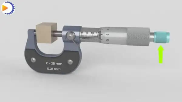 Un micromètre mesure un petit cube de bois. L'outil de précision affiche une mesure de 0 à 25 mm avec une précision de 0,01 mm.