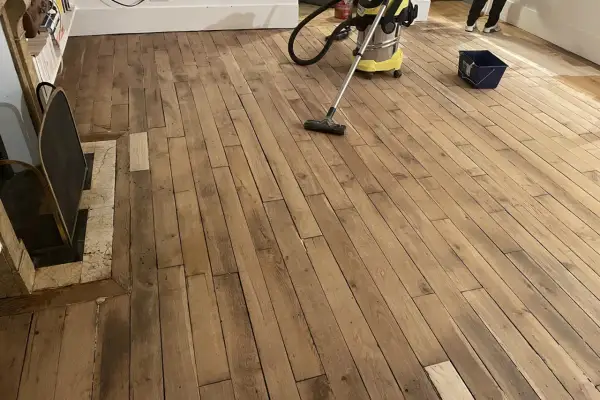 Nettoyage d'un parquet ancien avant vitrification. La question "vitrification parquet tous les combien" se pose souvent pour préserver sa beauté.